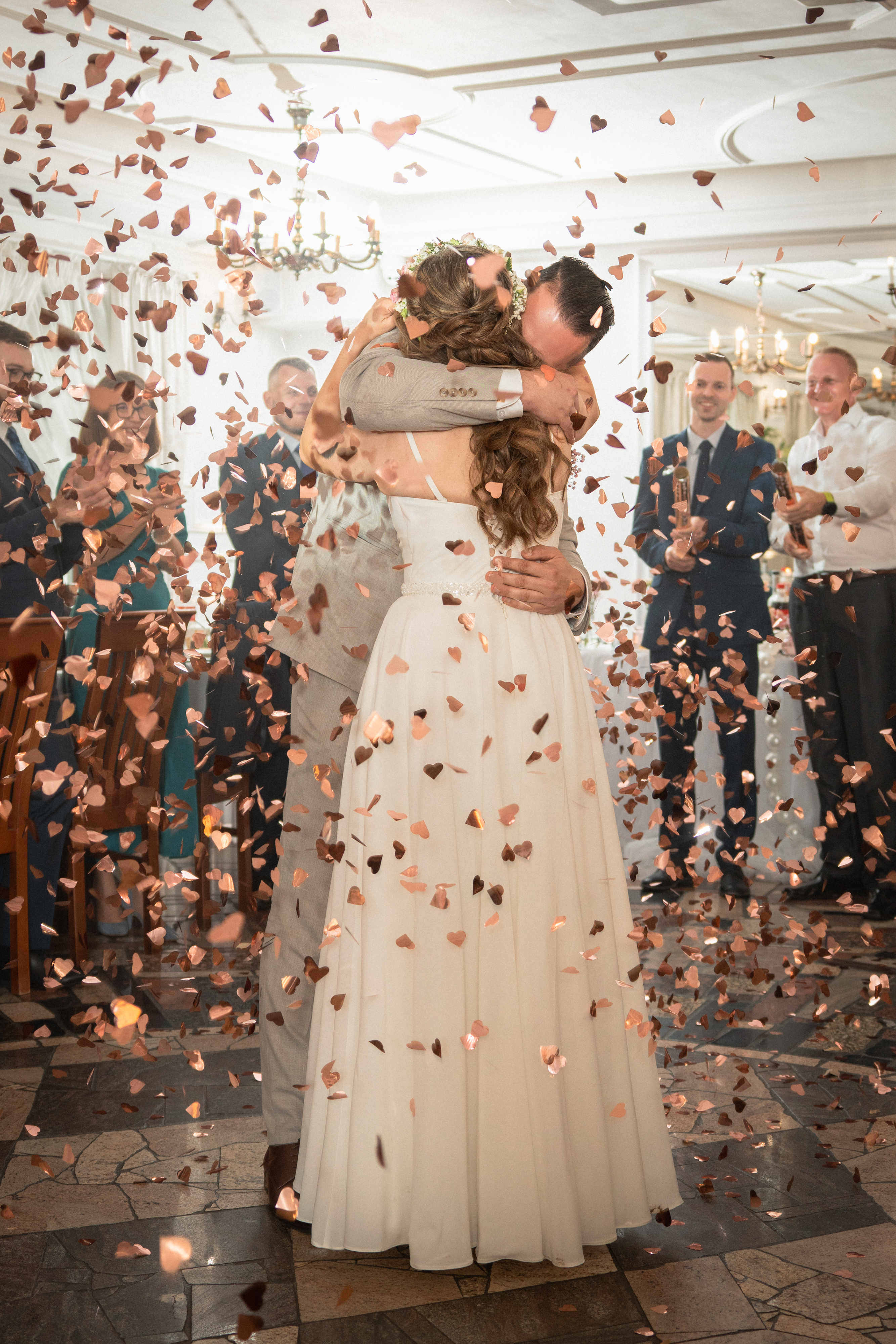 Para młoda wśród spadających płatków confetti po pierwszym tańcu.